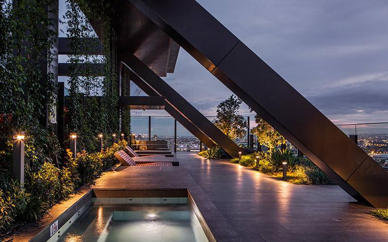 balcony view from the central park building in sydney with personal pools and wooden deck chairs