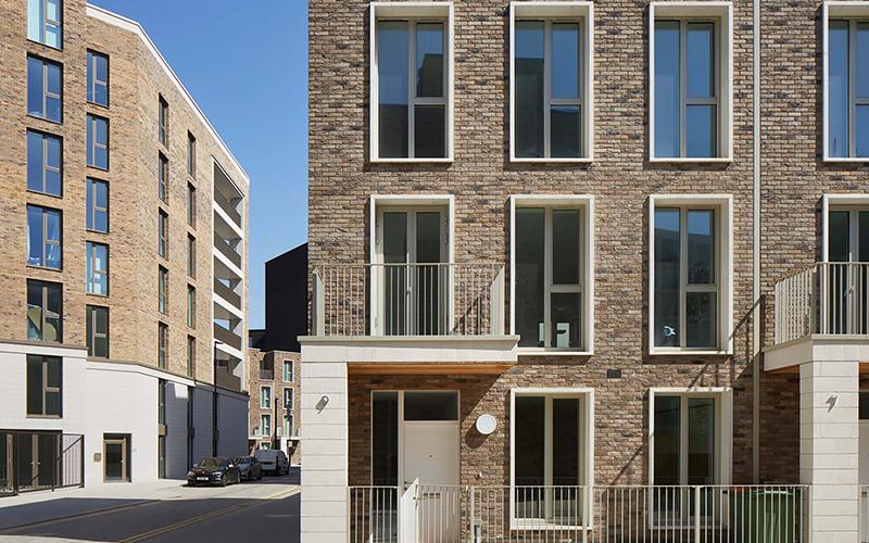 3D rendering of a brick apartment building on a street