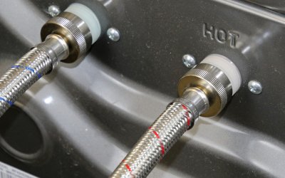 Close up of hot and cold washing machine connector hoses